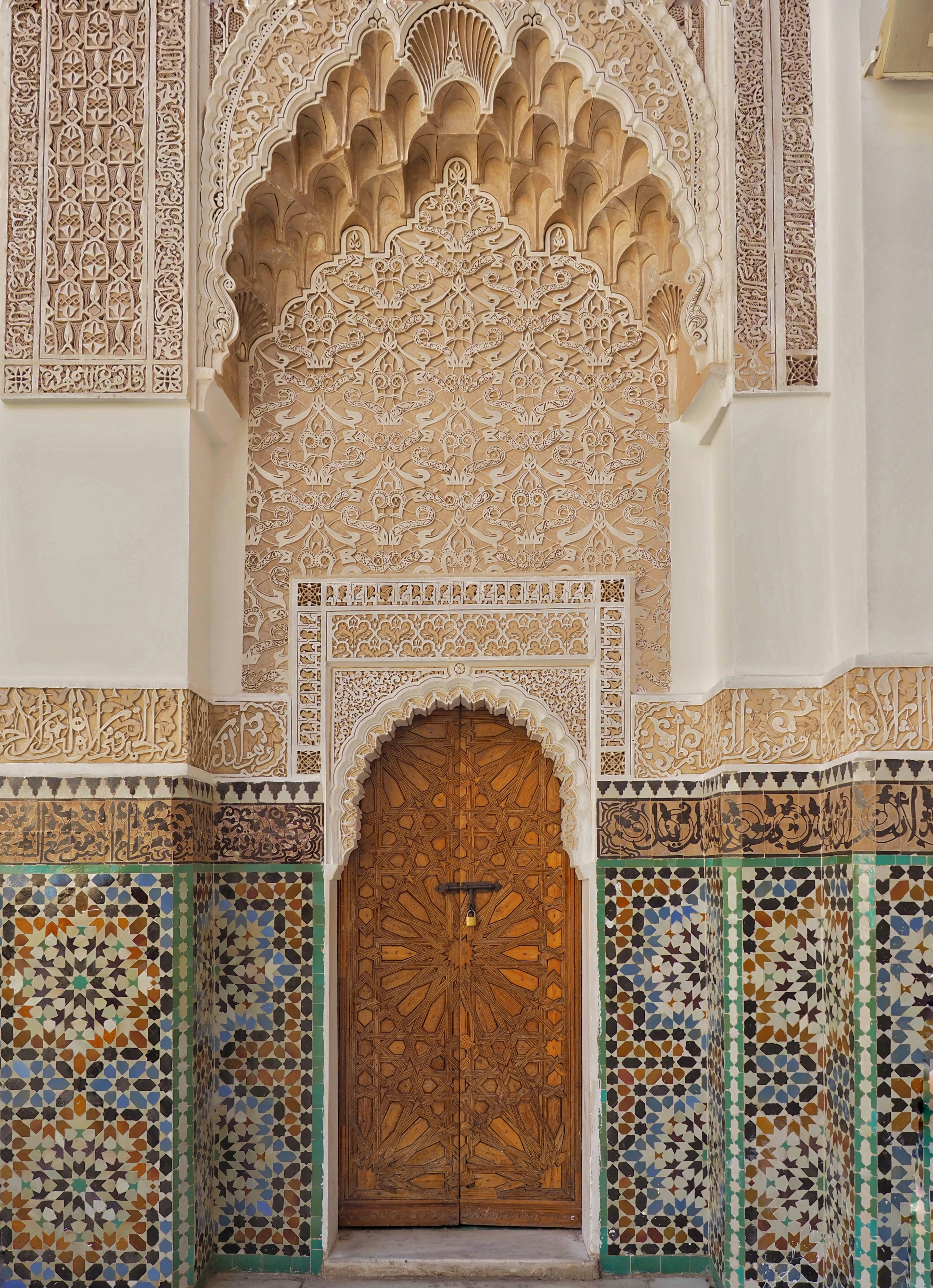 a doorway surrounded by mosaic and tiles in medresa ben youssef