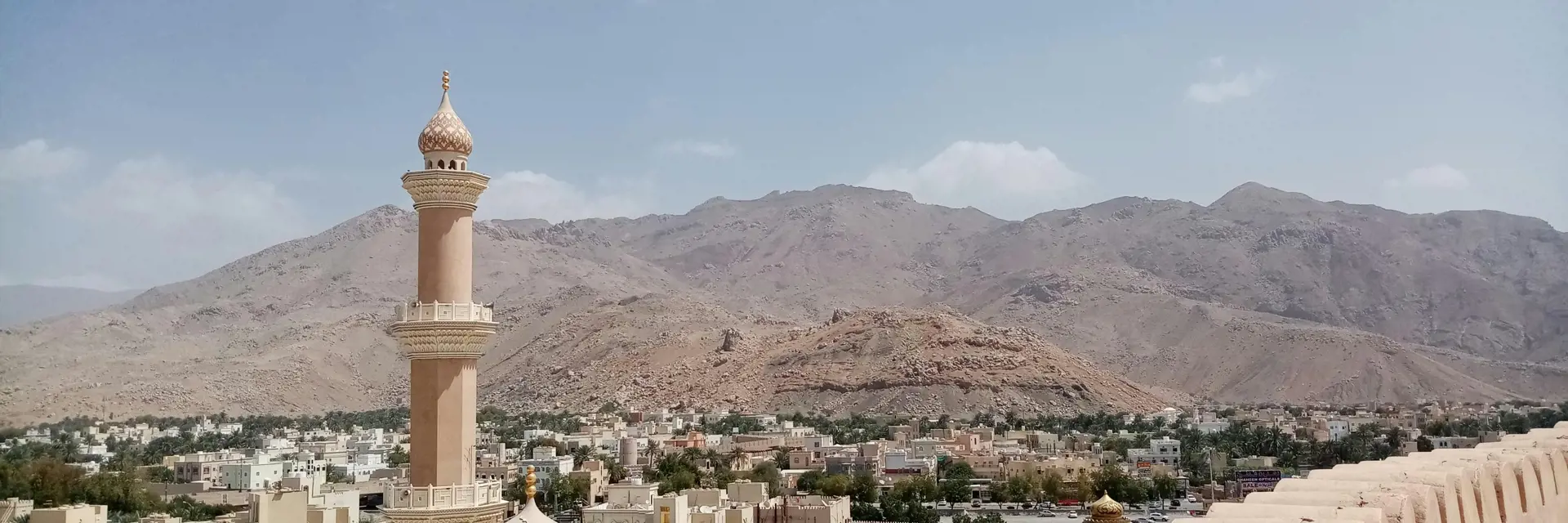 top view from the nizwa fort in oman with mountains and a mosque upfront